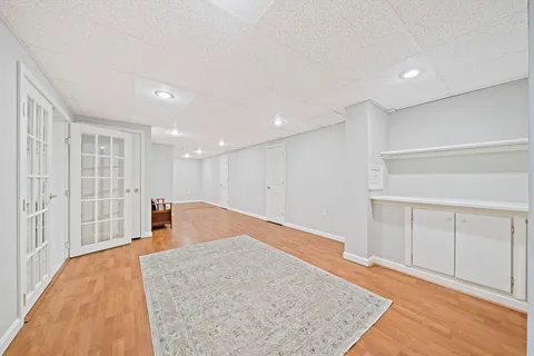 a view of a big room with wooden floor and windows