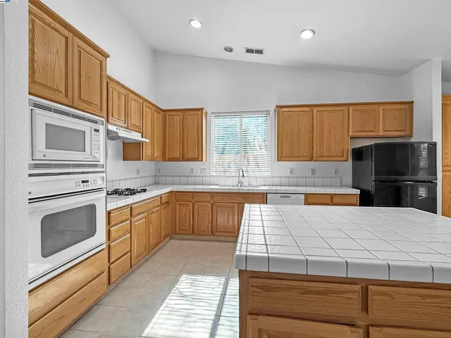 a kitchen with stainless steel appliances granite countertop a stove and a sink