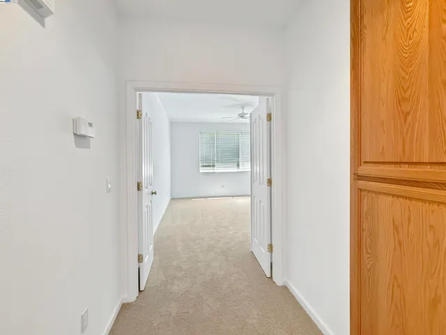 a view of a hallway with wooden shelves