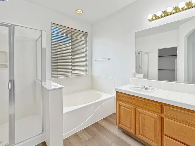 a bathroom with a tub sink and mirror