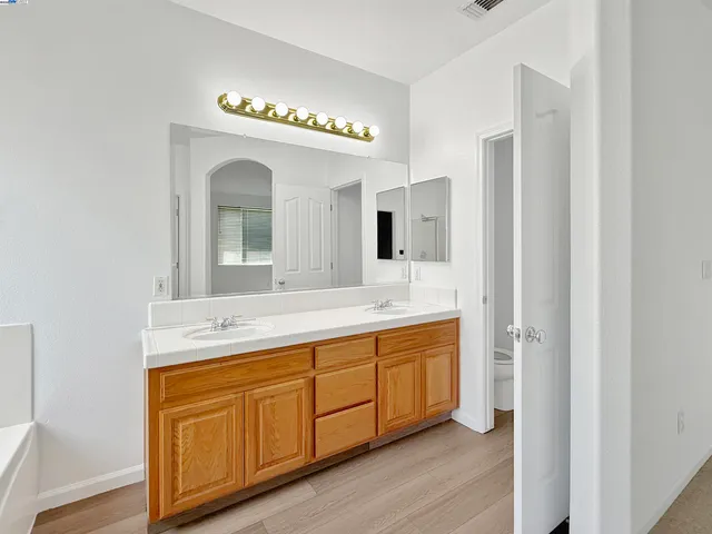a spacious bathroom with a double vanity sink and a mirror