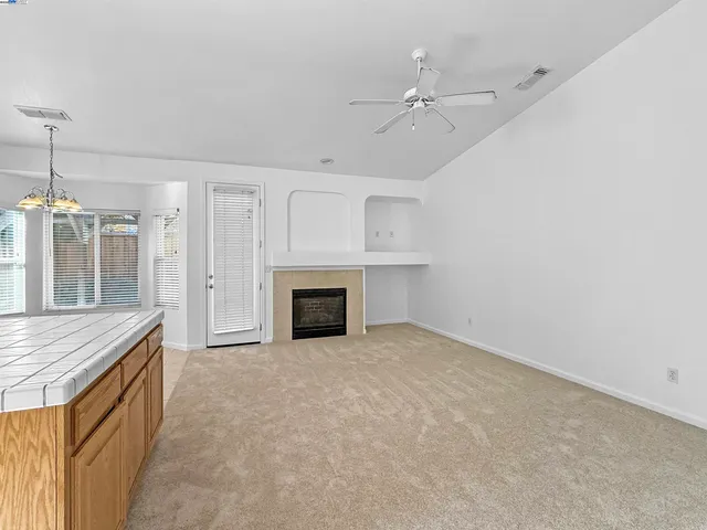 an empty room with a fireplace and chandelier
