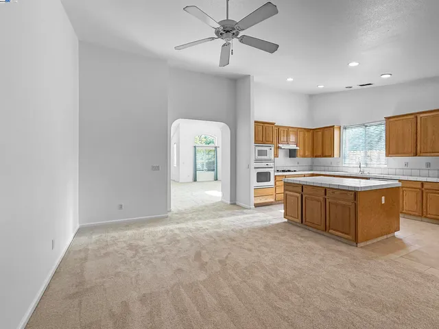 a large kitchen with a refrigerator and a stove top oven