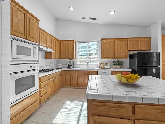 a kitchen with stainless steel appliances wooden cabinets and a stove top oven