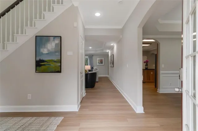 a view of a hallway with wooden floor and staircase