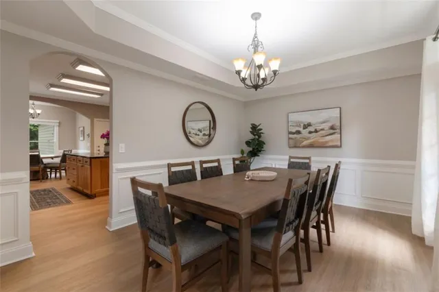 a view of a dining room with furniture a chandelier and wooden floor