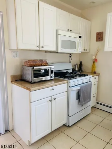 a kitchen with white cabinets and white appliances