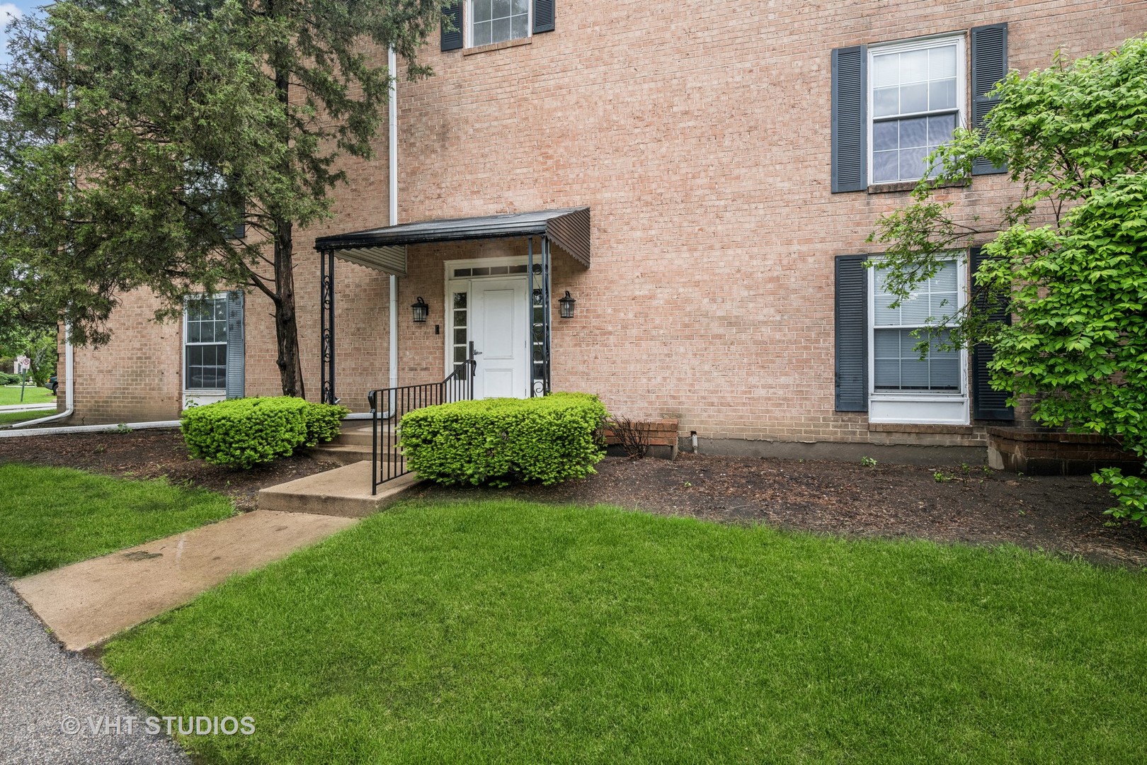 5300 Carriageway Drive, Unit 112 Rolling Meadows, IL 60008 - Photo 11 of 12 front view of a house with a yard and an trees