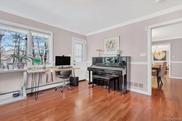 a living room with furniture and a flat screen tv with wooden floor