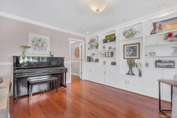 a living room with furniture and painting on the wall next to a window