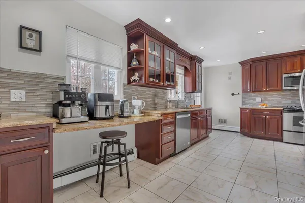 a kitchen with stainless steel appliances granite countertop a stove a sink and a refrigerator