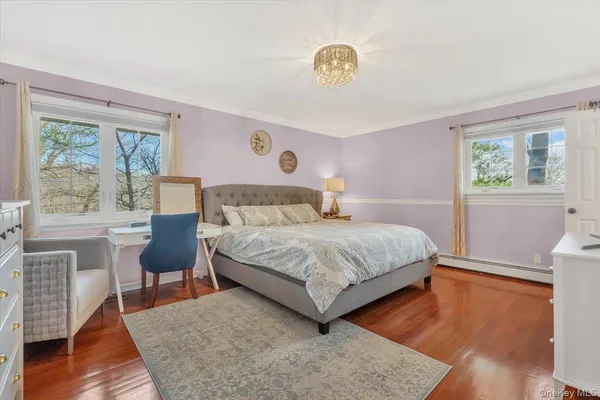a bedroom with a bed a table and chair with wooden floor