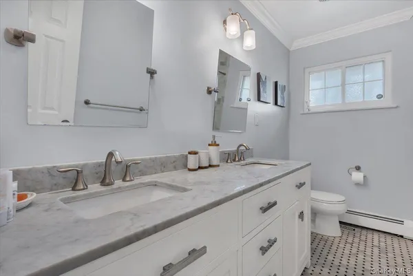 a bathroom with a granite countertop sink a toilet and a mirror