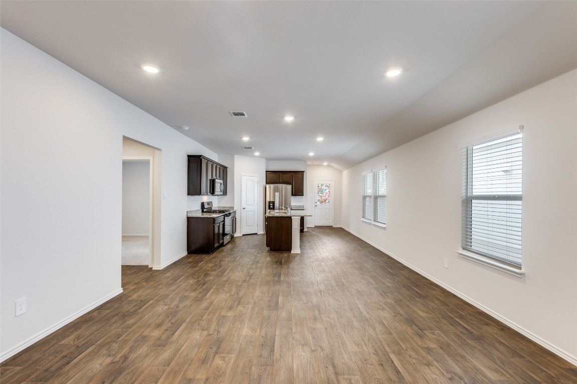 408 Frogmore Loop Kyle, TX 78640 - Photo 6 of 25 a view of a kitchen with a sink and dishwasher a refrigerator with wooden floor