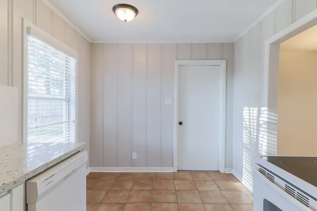 a view of an empty room with window and cabinet