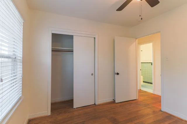 a view of an empty room with closet and a window