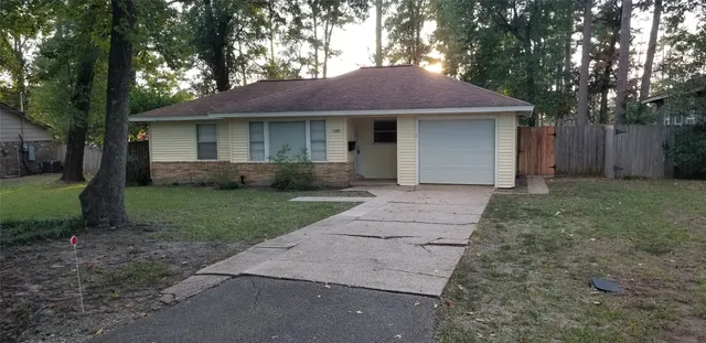 a front view of a house with a garden and trees
