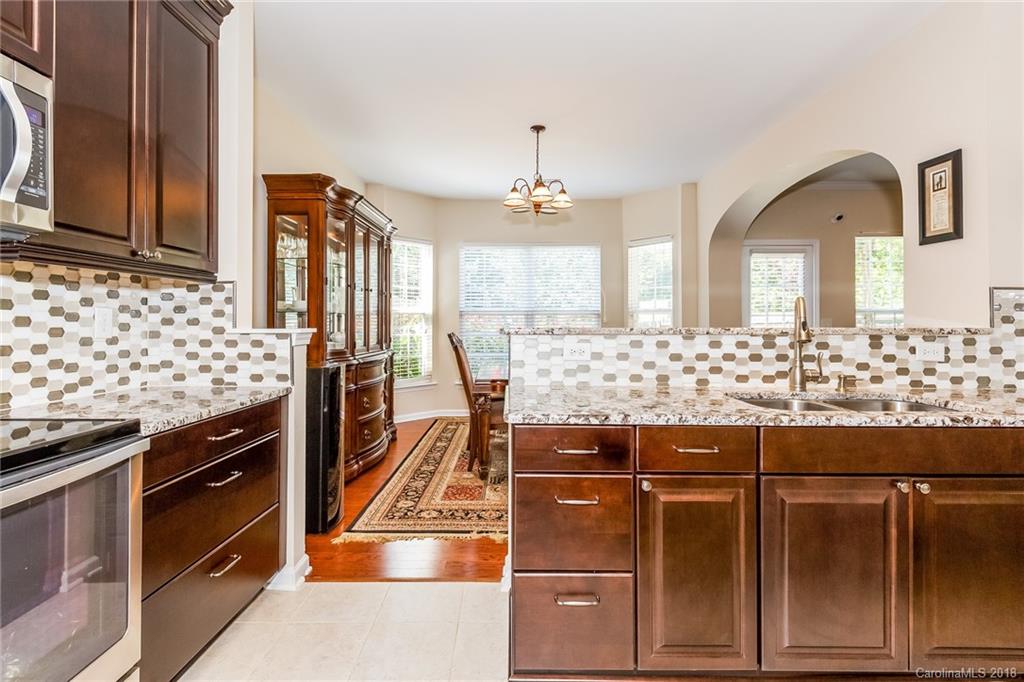 3900 Caliper Place Fort Mill, SC 29708 - Photo 12 of 27 a kitchen with stainless steel appliances kitchen island granite countertop a stove and a sink