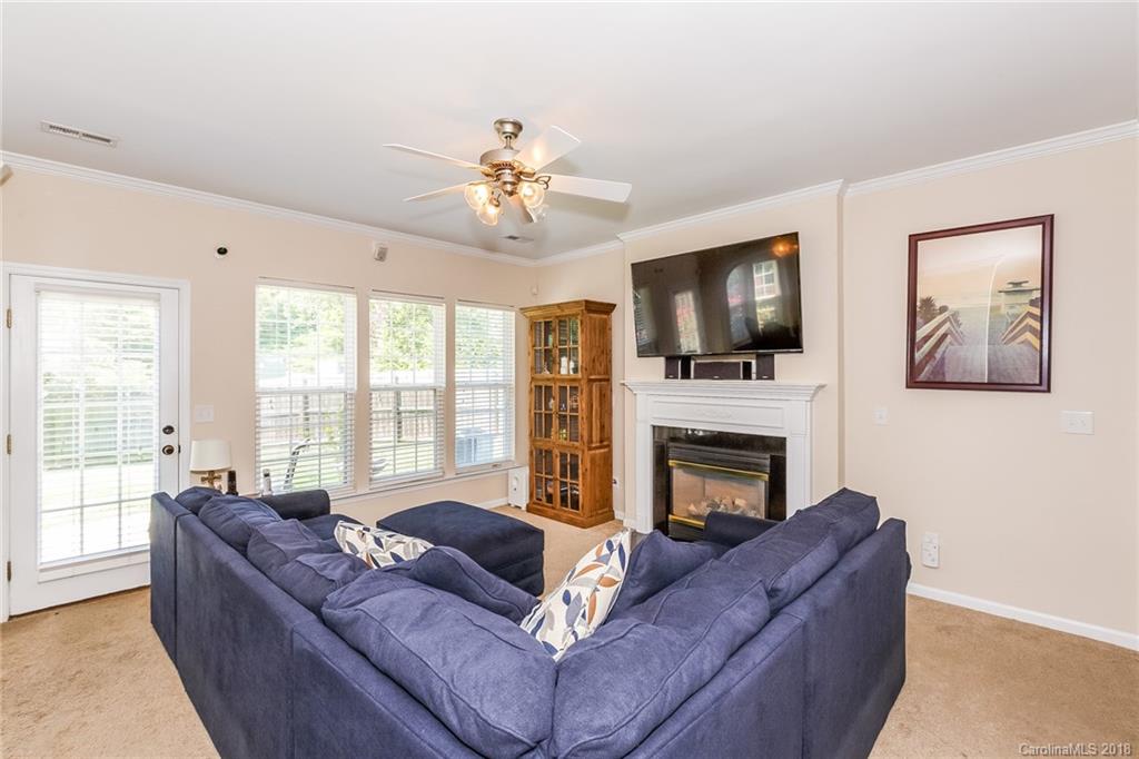 3900 Caliper Place Fort Mill, SC 29708 - Photo 6 of 27 a living room with furniture a flat screen tv and a fireplace