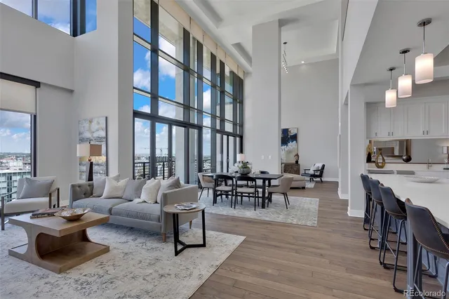 a living room with furniture wooden floor and a large window