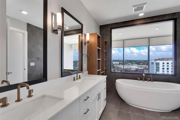 a view of an empty room with wooden floor and fan