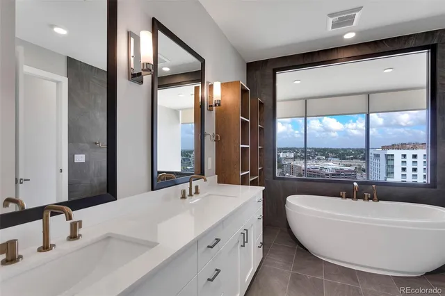 a view of an empty room with wooden floor and fan