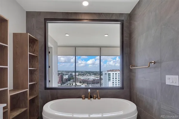 a view of an empty room with wooden floor and a large window