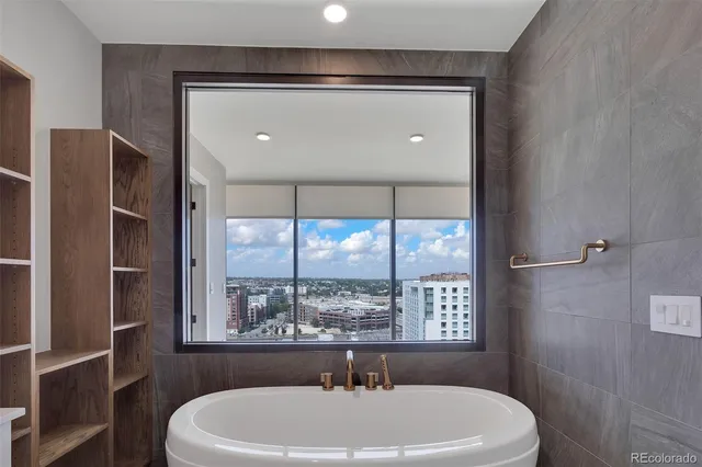 a view of an empty room with wooden floor and a large window