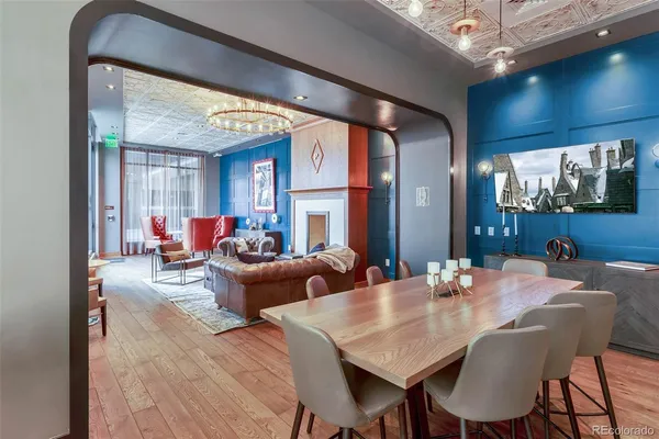 a dining room with wooden floor and large windows