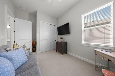 a bedroom with a bed and dresser next to a window