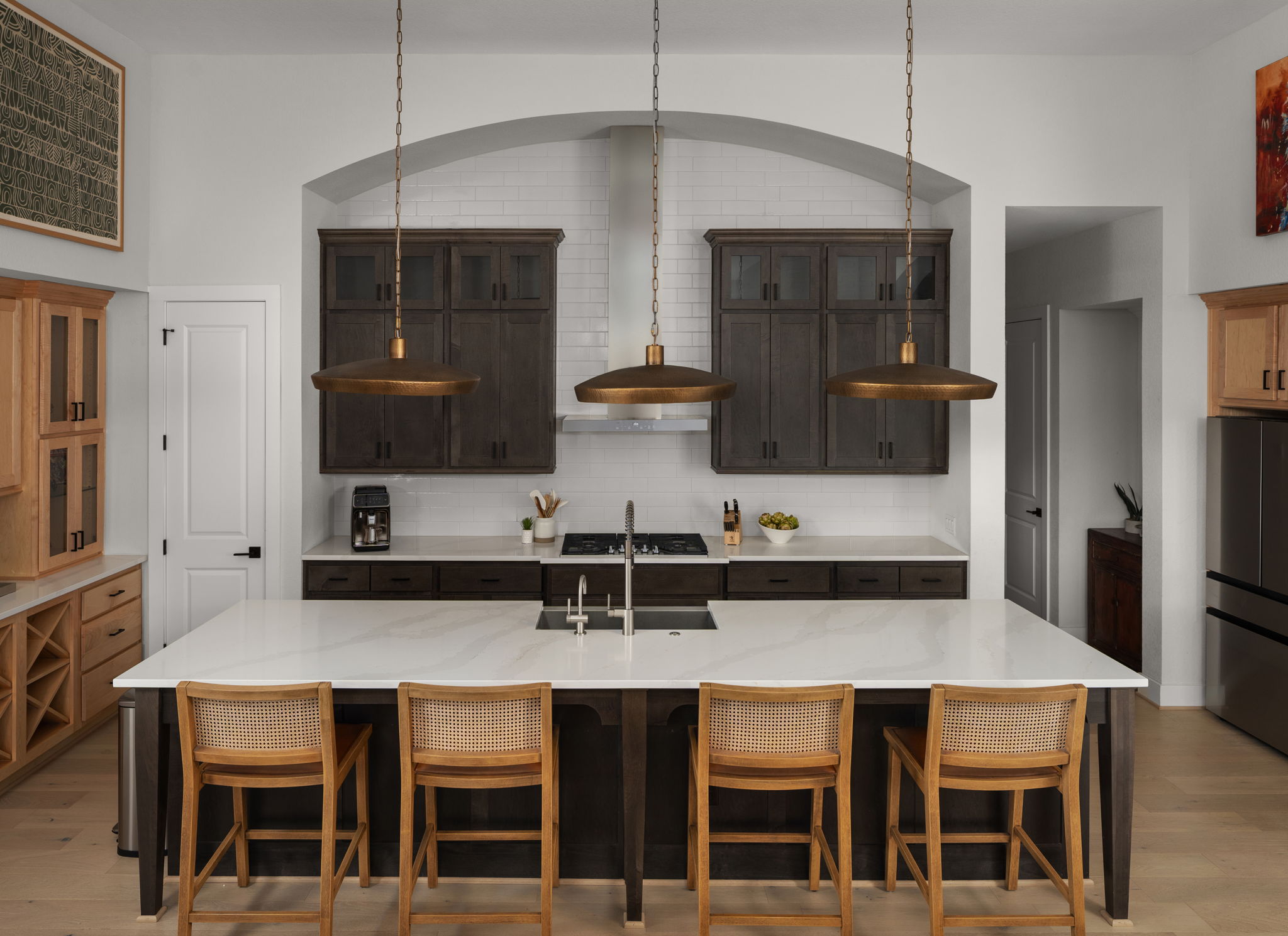 a kitchen with stainless steel appliances granite countertop a table chairs in it and wooden floors