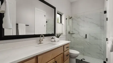 a bathroom with a sink toilet a mirror and shower