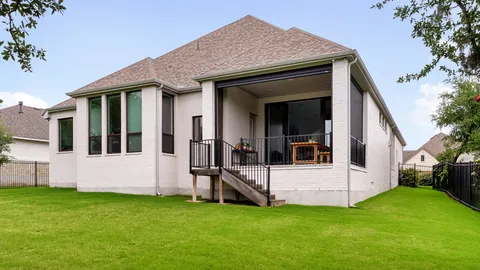 a view of a white house with a big yard with garden