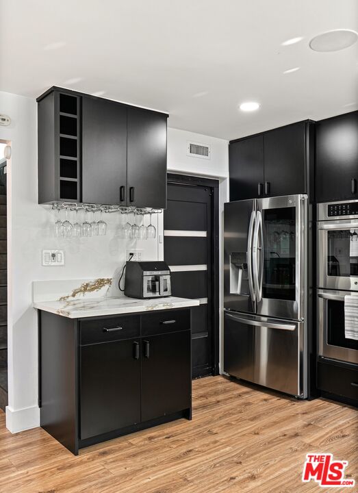 4118 Oak Hollow Road Calabasas, CA 91302 - Photo 22 of 55 a kitchen with stainless steel appliances kitchen island granite countertop a refrigerator and a stove top oven