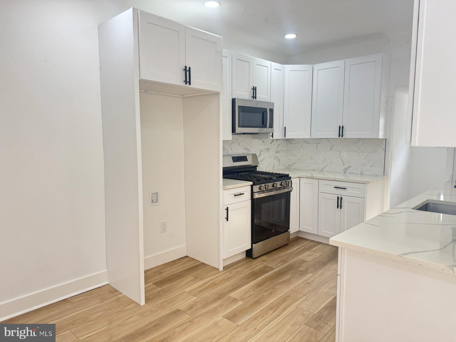 894 Sanger Street Philadelphia, PA 19124 - Photo 12 of 35 a kitchen with white cabinets and white appliances