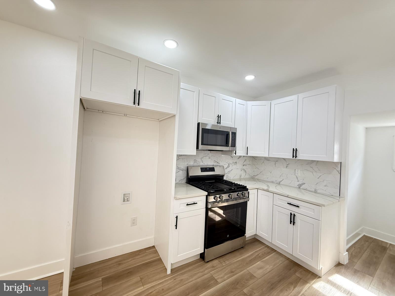 894 Sanger Street Philadelphia, PA 19124 - Photo 13 of 35 a kitchen with stainless steel appliances white cabinets and a stove top oven