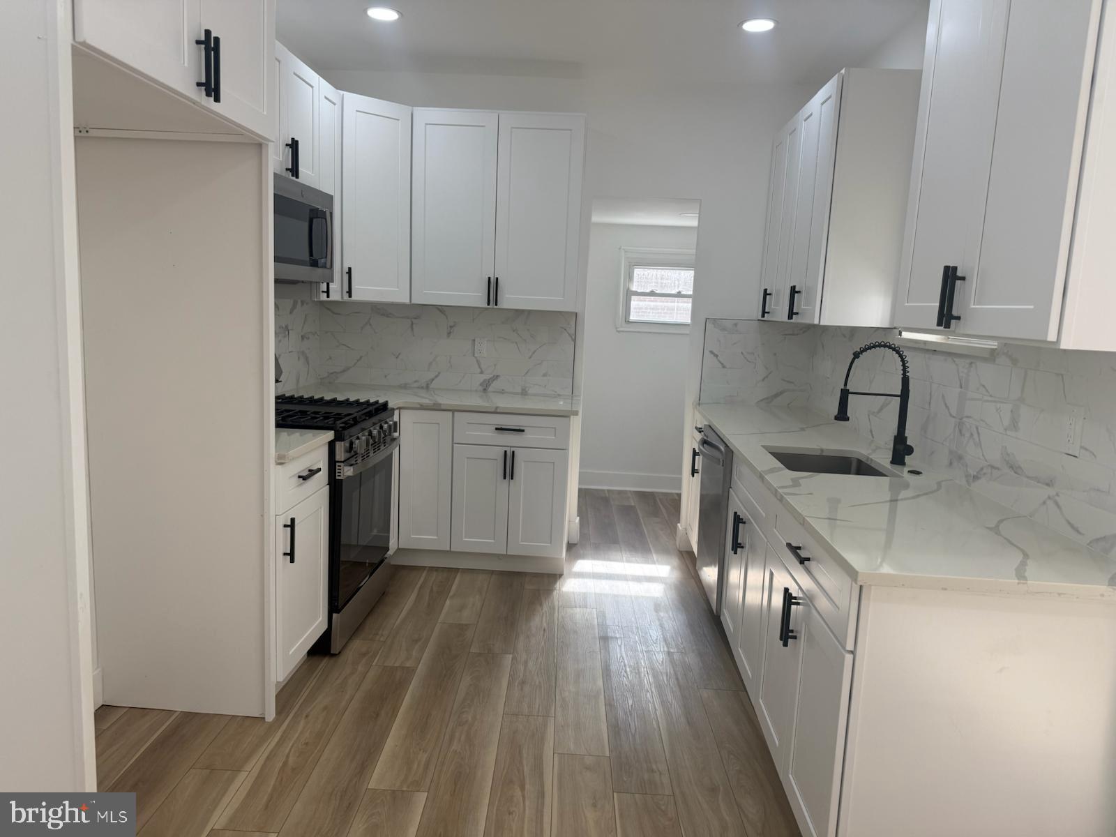 894 Sanger Street Philadelphia, PA 19124 - Photo 14 of 35 a kitchen with stainless steel appliances granite countertop a sink stove and refrigerator