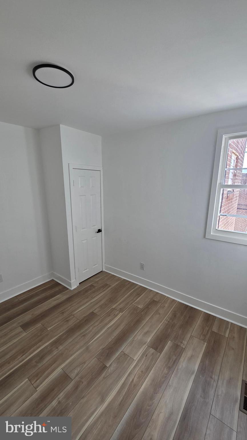 894 Sanger Street Philadelphia, PA 19124 - Photo 19 of 35 a view of an empty room with wooden floor and a window