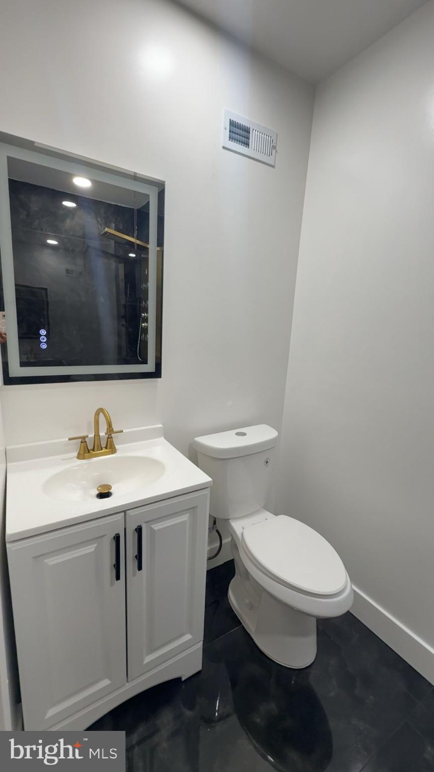 894 Sanger Street Philadelphia, PA 19124 - Photo 23 of 35 a bathroom with a toilet a sink and mirror