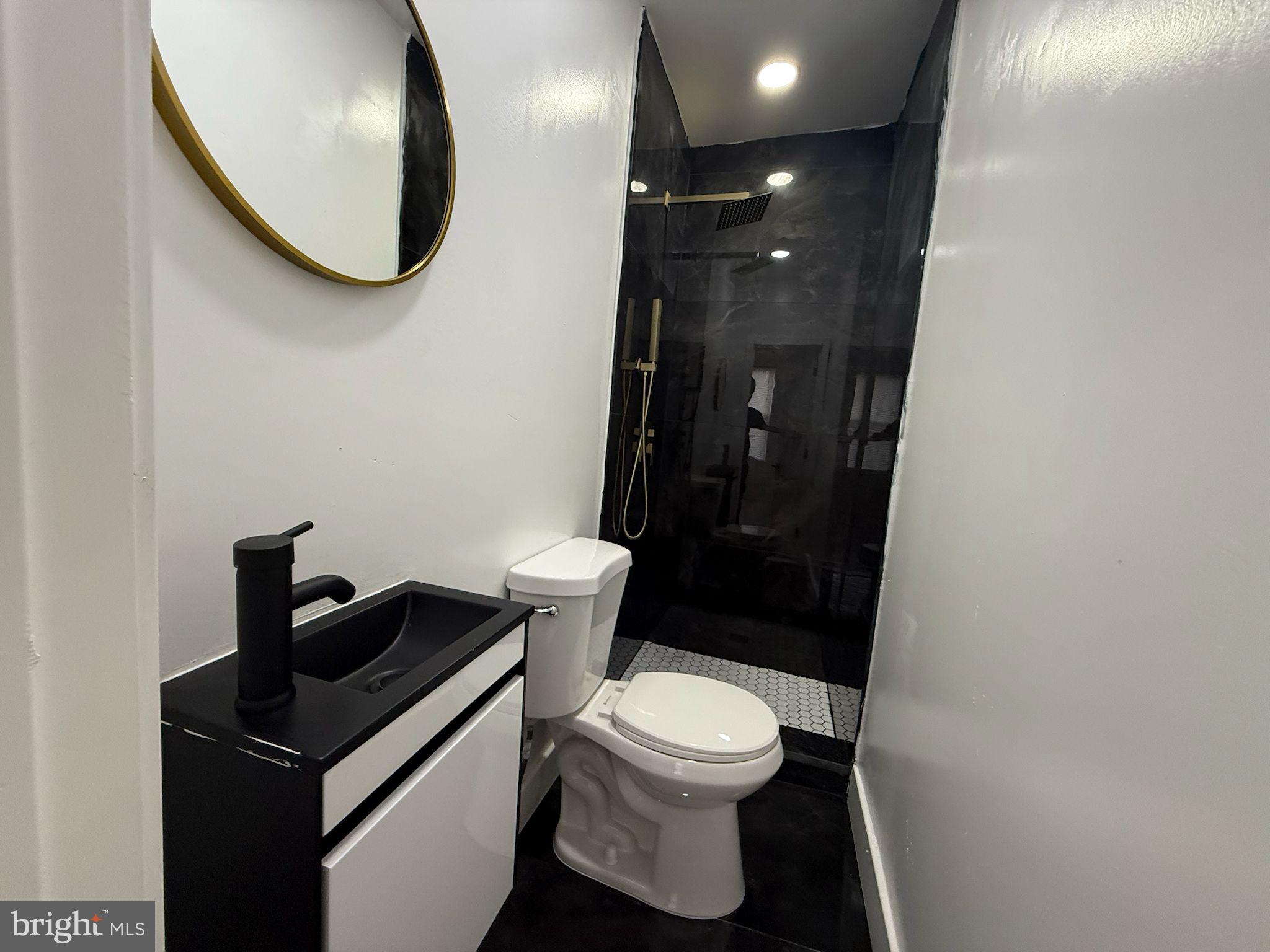 894 Sanger Street Philadelphia, PA 19124 - Photo 24 of 35 a bathroom with a toilet a sink and a mirror