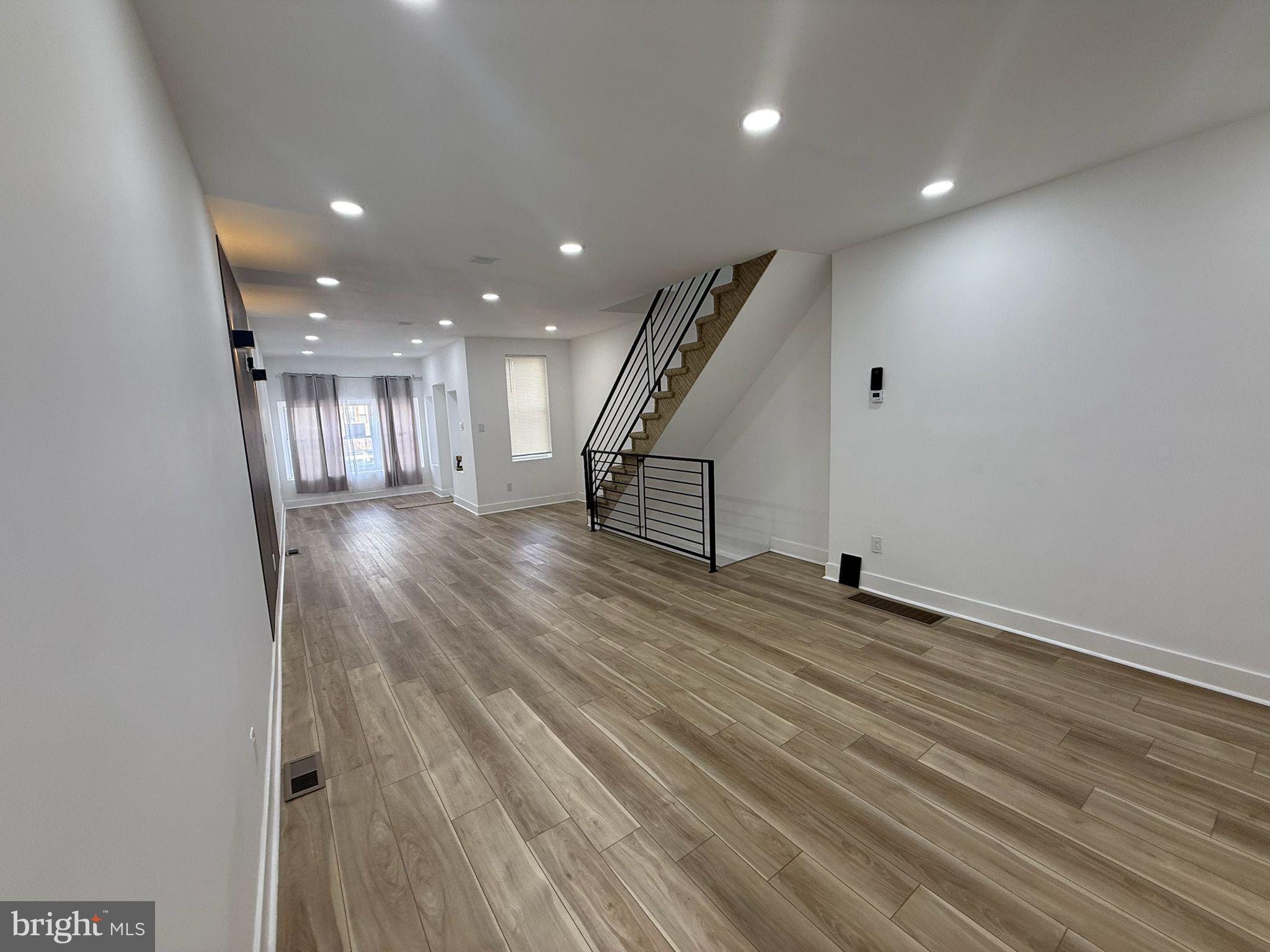 894 Sanger Street Philadelphia, PA 19124 - Photo 9 of 35 an empty room with wooden floor and stairs