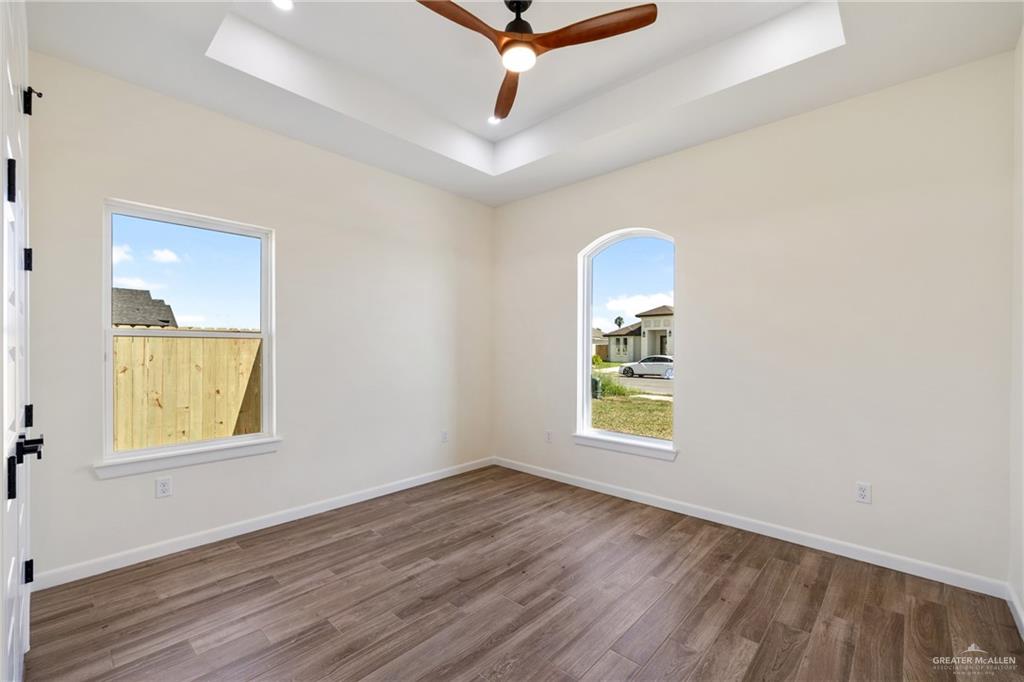 1602 Helen Drive Weslaco, TX 78596 - Photo 11 of 32 an empty room with wooden floor cabinet and windows