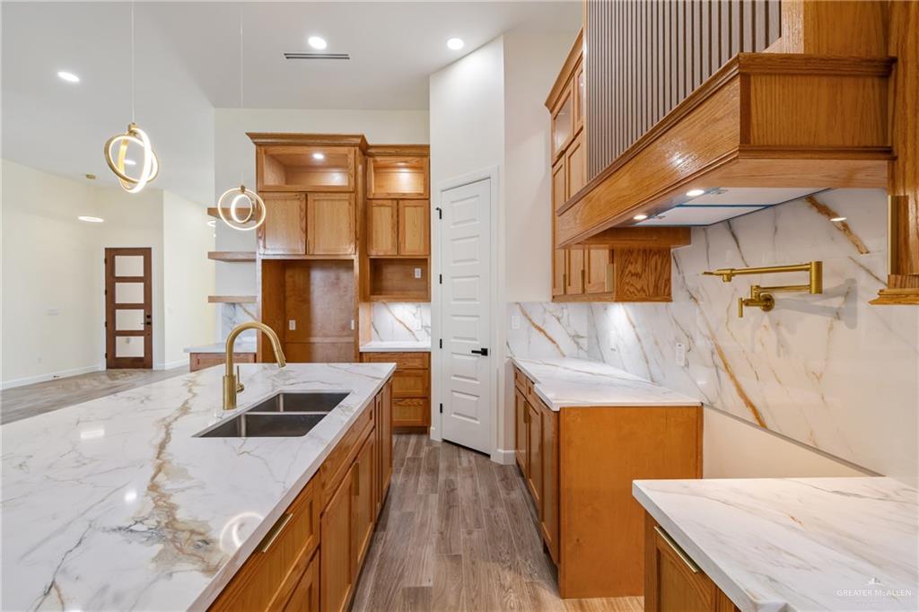 1602 Helen Drive Weslaco, TX 78596 - Photo 8 of 32 a kitchen with stainless steel appliances granite countertop a sink a stove and a wooden floors