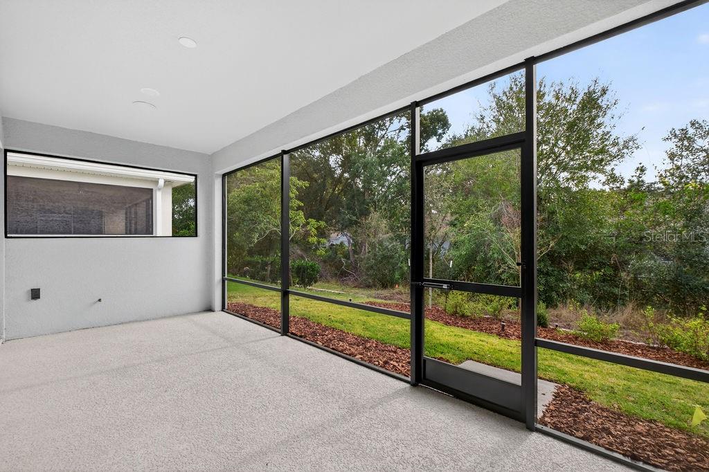 2046 Wallingford Loop Mount Mount Dora, FL 32757 - Photo 34 of 55 a view of an empty room with floor to ceiling windows and tree
