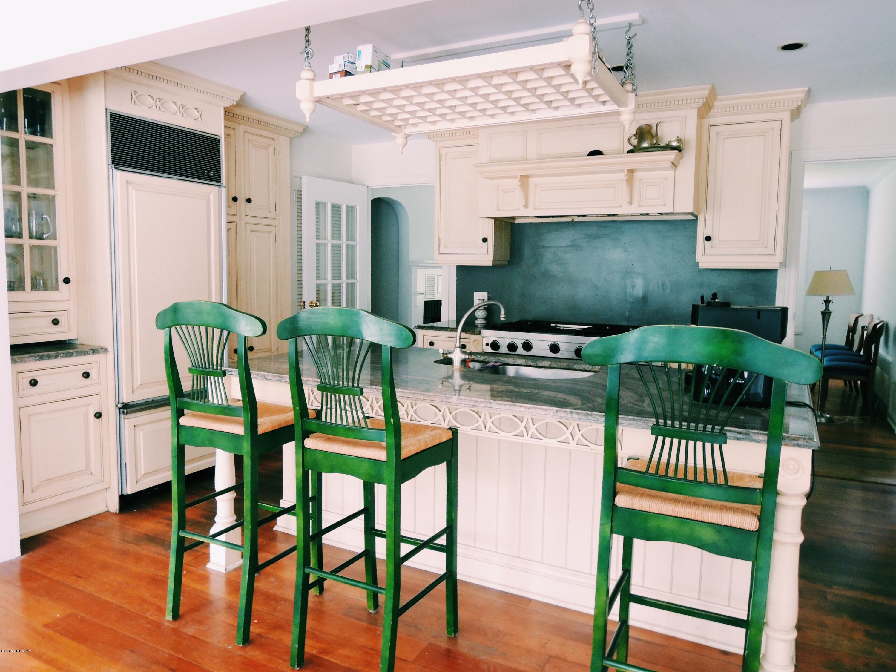 74 Howard Road Greenwich, CT 06831 - Photo 3 of 25 a kitchen with stainless steel appliances kitchen island granite countertop a table and chairs in it