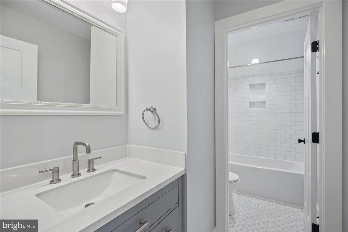 206 Point Lane Solomons, MD 20688 - Photo 34 of 46 a bathroom with a shower sink vanity and mirror