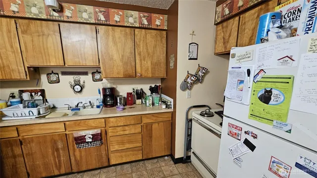 a kitchen with stainless steel appliances granite countertop a refrigerator and a stove top oven