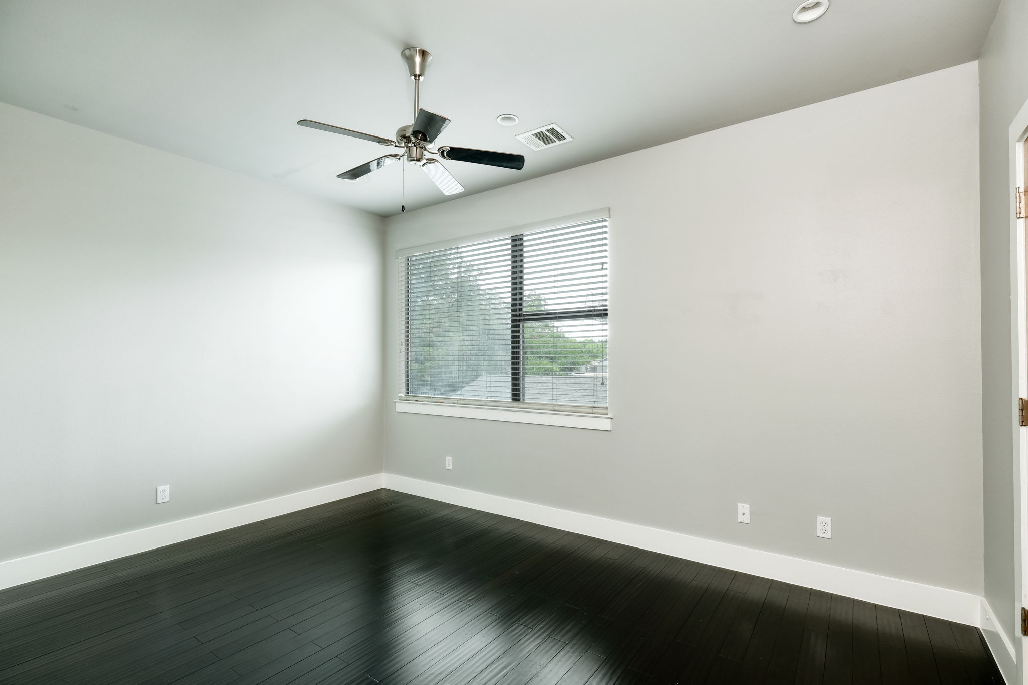 3000 Speedway Street, Unit E Austin, TX 78705 - Photo 8 of 16 Rich hardwood floors complement this spacious, naturally illuminated room, offering an inviting atmosphere.
