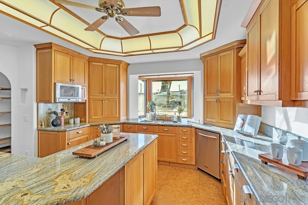 13419 Sebago Avenue Poway, CA 92064 - Photo 16 of 49 a kitchen with a sink stove and cabinets