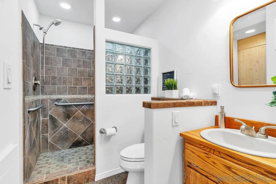 13419 Sebago Avenue Poway, CA 92064 - Photo 29 of 49 a bathroom with a sink a mirror a toilet and a shower
